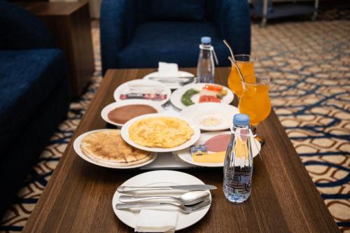Una mesa con platos de comida y bebidas sobre ella. en فندق اهلا Hola Hotel, en Al Jubail