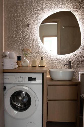 a bathroom with a washing machine and a sink at Alexandra Heritage Μaison in Archanes
