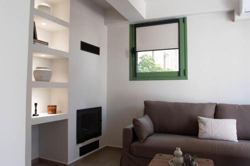 a living room with a couch and a window at Alexandra Heritage Μaison in Archanes
