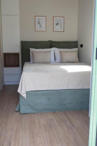 a bedroom with a large bed with a wooden floor at Alexandra Heritage Μaison in Archanes