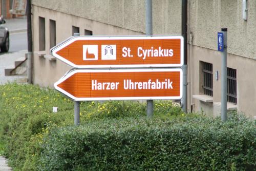 three orange street signs in front of a building at harz-traum in Gernrode - Harz