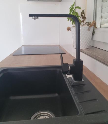 a kitchen sink with a faucet on a counter at Lavender Apartments in Drage