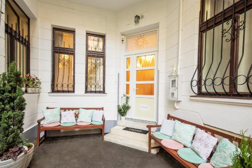 a porch with two benches and some windows at Eden Center Home in Győr