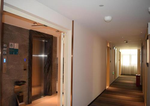 a hallway with a walk in shower in a building at City Comfort Inn Meishan Sansu Temple in Meishan