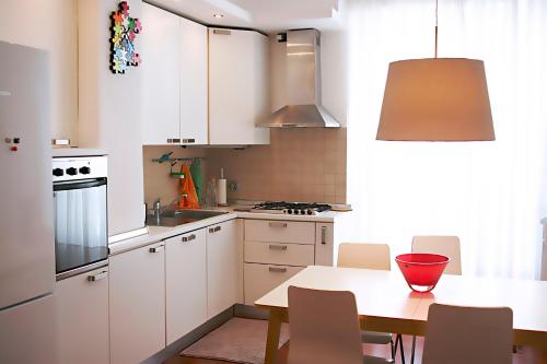a kitchen with white cabinets and a table with chairs at Albero della fortuna in Turin