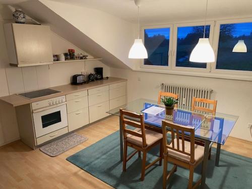 a kitchen with a glass table and chairs in a kitchen at Oberdorf in Konstanz