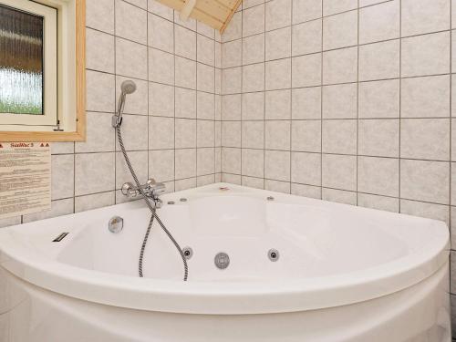 ブラーバンドにあるEco-Friendly Retreat with Spa - By Traum Ferienwohnungenのタイル張りの浴室にある白い浴槽