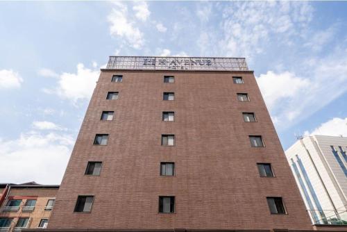 a tall brick building with a sign on it at H Avenue Hotel Jeonju Terminal in Jeonju