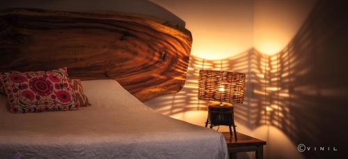 a bedroom with a bed and a lamp on a table at Villa Nao in Roxton Falls