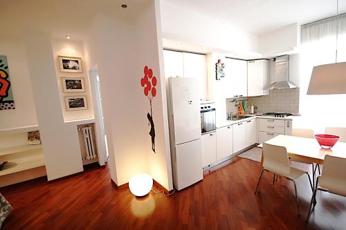 a kitchen with a table and a white refrigerator at Albero della fortuna in Turin