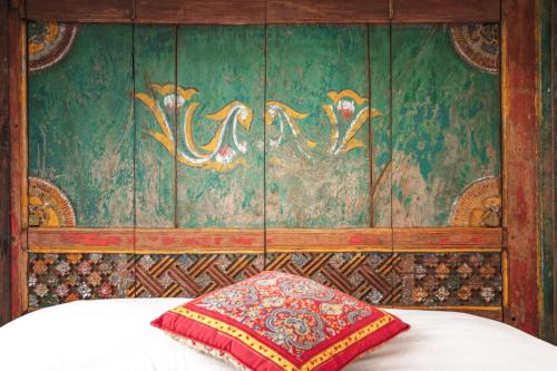 a bedroom with a green wall with a pillow on a bed at Villa Nao in Roxton Falls