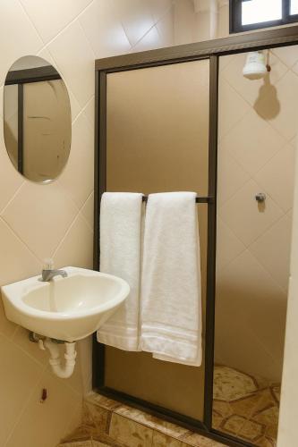 a bathroom with a sink and a shower with towels at Sol Coral in Valdivia
