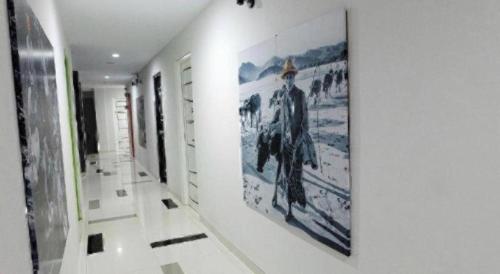 a hallway with paintings on the wall in a building at Fizz Hotel Lombok in Tanjungkarang