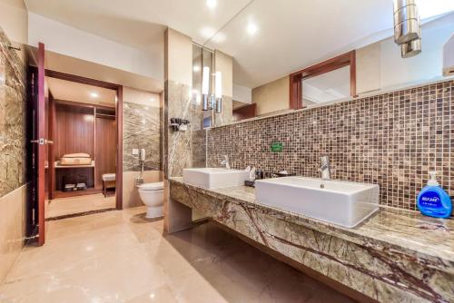 une salle de bain avec deux lavabos et un WC dans l'établissement Moon Crescent Hotel (Chengdu West Steition Culture Palace Metro Stetion Branch), à Supoqiao