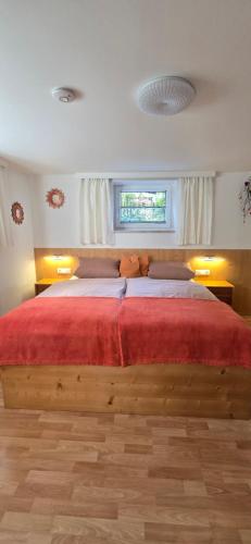 a bedroom with a large wooden bed with a red blanket at Apartment Hausberger in Mayrhofen