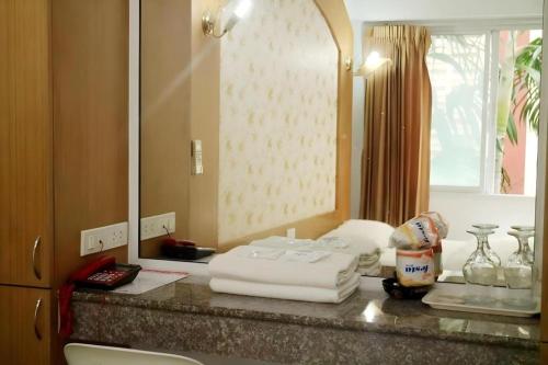 a bathroom with a counter with towels and a mirror at Diamond Sweet Hotel in Bangkok