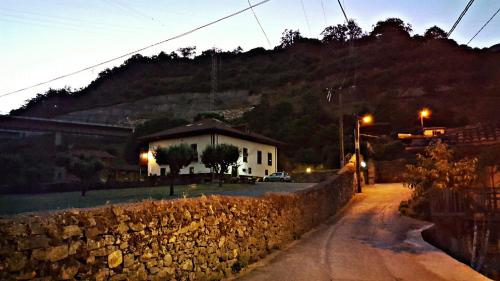 a building with a stone wall next to a street at Hotel Rural Palacio de Galceran in Sotiello