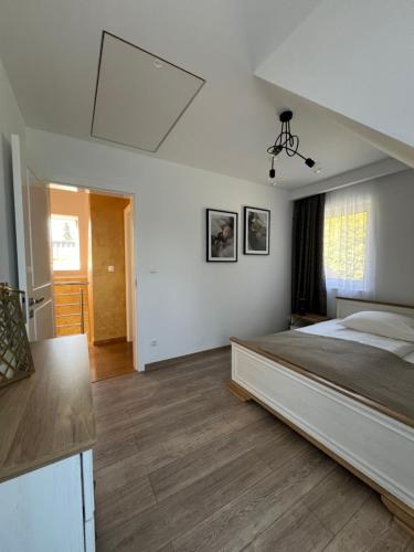 a bedroom with a large bed and a kitchen at Dom na Borówkowym Wzgórzu in Paleśnica