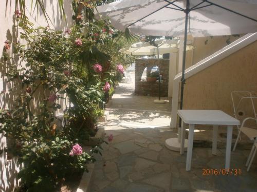 a patio with flowers and a table and an umbrella at Anastasia Apartments in Korissia