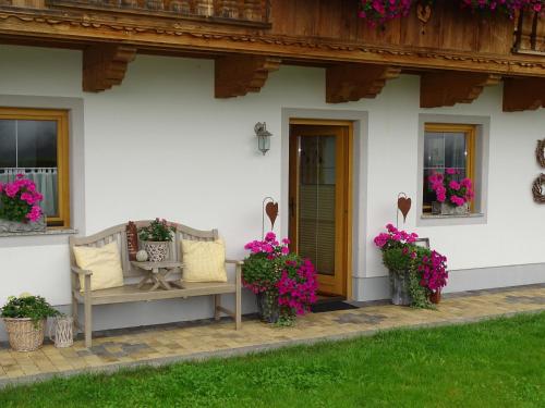 a porch of a house with a bench and flowers at Anna's Appartement in Alpbach