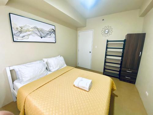 a bedroom with a bed with a yellow bedspread at Corner 1 Bedroom Unit at Centrio Tower in Cagayan de Oro