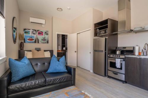 a living room with a leather couch in a kitchen at Stay Portland - Sleek Studio - Food Cart Row & Vintage Shops in Portland