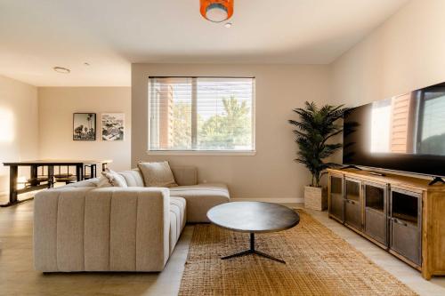 a living room with a couch and a table and a tv at Stay Portland - Modern Home in Foodie District - 2BR - Sleeps 4 in Portland