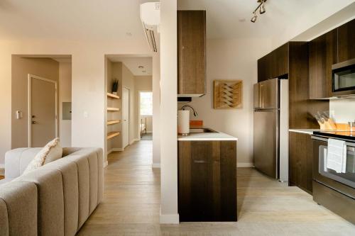 a kitchen with wooden cabinets and a couch in a room at Stay Portland - Modern Home in Foodie District - 2BR - Sleeps 4 in Portland