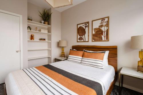 a bedroom with a bed with white and orange pillows at Stylish Portland 1BR w 90 WalkScore in Portland