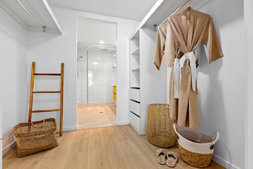 a room with a closet with a robe and baskets at Drift North Beachfront Apartments - Private Apartments in Kingscliff
