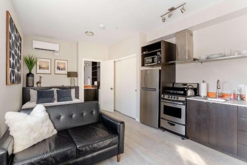 a living room with a couch and a kitchen at Stay Portland - Modern Portland Studio - Food Carts & Local Shops in Portland