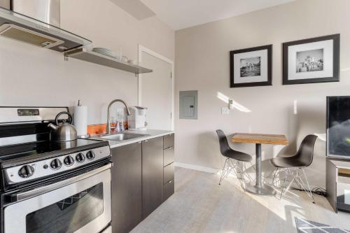 a kitchen with a stove and a sink and a table at Stay Portland - Modern Portland Studio - Food Carts & Local Shops in Portland