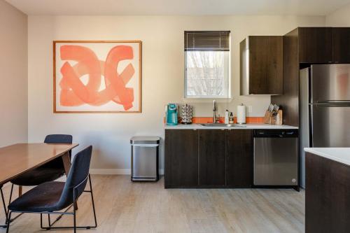 a kitchen with a sink and a table with chairs at Stay Portland - The Mid-Century Cabin in Portland - Thrift & Eat in Portland