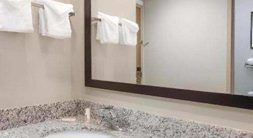 a bathroom with a sink and a large mirror at Days Inn Springfield South in Springfield
