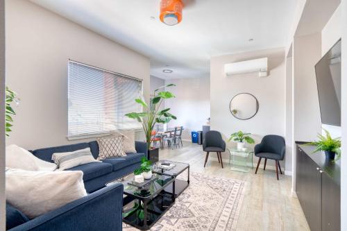 a living room with a blue couch and a table at Portland Penthouse Retreat- Roof Deck & Food Pods in Portland