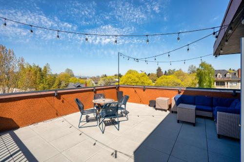 a patio with a table and chairs on a roof at Portland Penthouse Retreat- Roof Deck & Food Pods in Portland