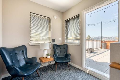 two chairs and a table in a room with a window at Portland Penthouse Retreat- Roof Deck & Food Pods in Portland