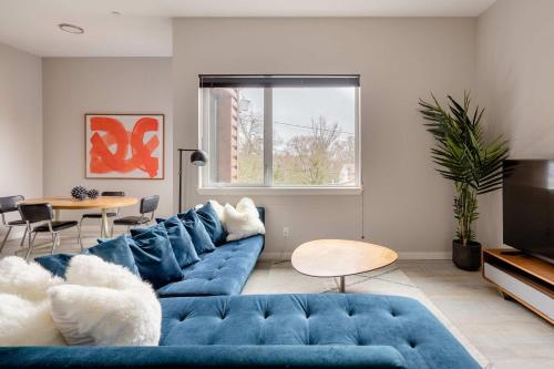 a living room with a blue couch and a table at Stay Portland - Retro Modern 2-Bedroom with 90 WalkScore in Portland