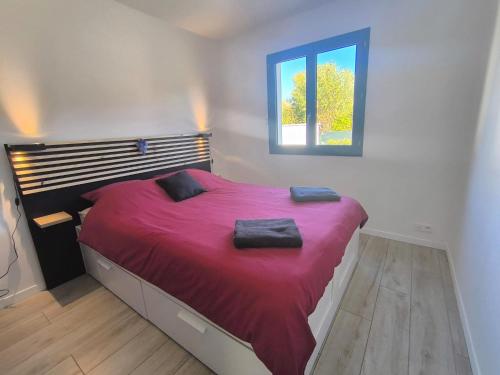 a bedroom with a large red bed with a window at Entre Bois et Lumiere in Le Brusquet