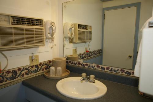 a bathroom with a sink and a mirror at Bennington Motor Inn in Bennington