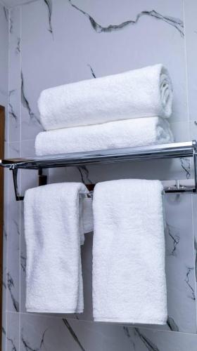 a towel rack with white towels in a bathroom at Badyan Boutique Hotel in Bukhara in Bukhara