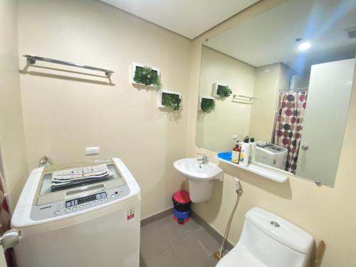 a small bathroom with a toilet and a sink at Corner 1 Bedroom Unit at Centrio Tower in Cagayan de Oro