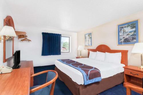 a hotel room with a bed and a desk at Super 8 By Wyndham Montgomery Maybrook in Montgomery