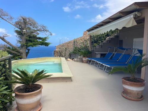 a patio with a swimming pool and chairs on a house at VILLA ŚWISTAKKO in Costa Paradiso