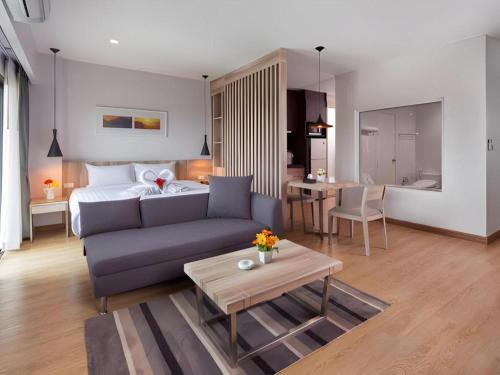 a living room with a couch and a bed at The Canal 304 in Si Maha Phot