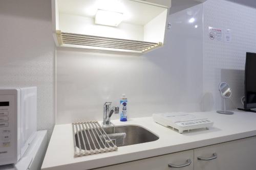 una cucina con lavello e microonde di Smart VILLA Hatanodai I a Tokyo
