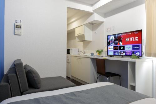 una camera da letto con scrivania e computer di Smart VILLA Hatanodai I a Tokyo