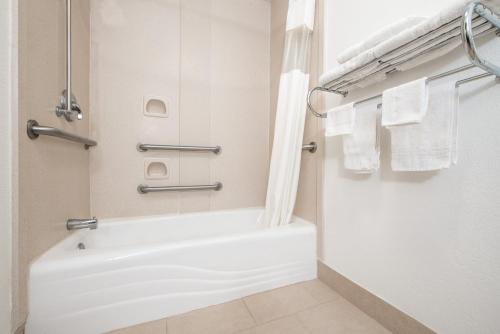 a bathroom with a tub and a shower with towels at Quality Inn & Suites Clayton, NM in Clayton