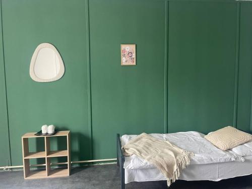 ein Schlafzimmer mit grünen Wänden, einem Bett und einem Tisch in der Unterkunft Carlsbad Wellness & Camping Resort in Pirkenhammer