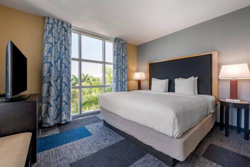 a bedroom with a large bed and a large window at Cambria Hotel Ft Lauderdale, Airport South & Cruise Port in Dania Beach